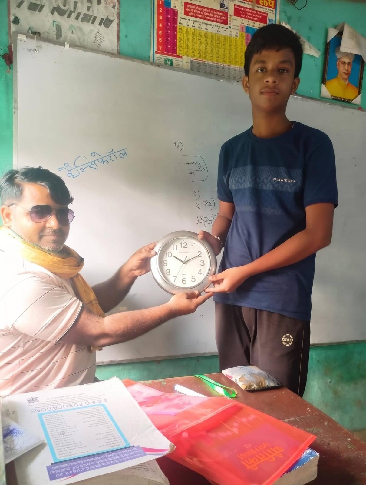 A student receives a wall clock as a prize in front of the whiteboard